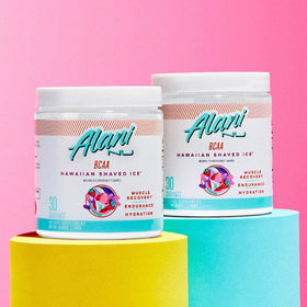 Alani Nu BCAA Poudre 30 Servings sur un fond de gym