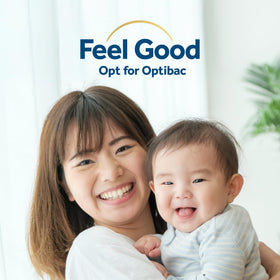 Bébé prenant des gouttes Optibac Probiotics avec un parent