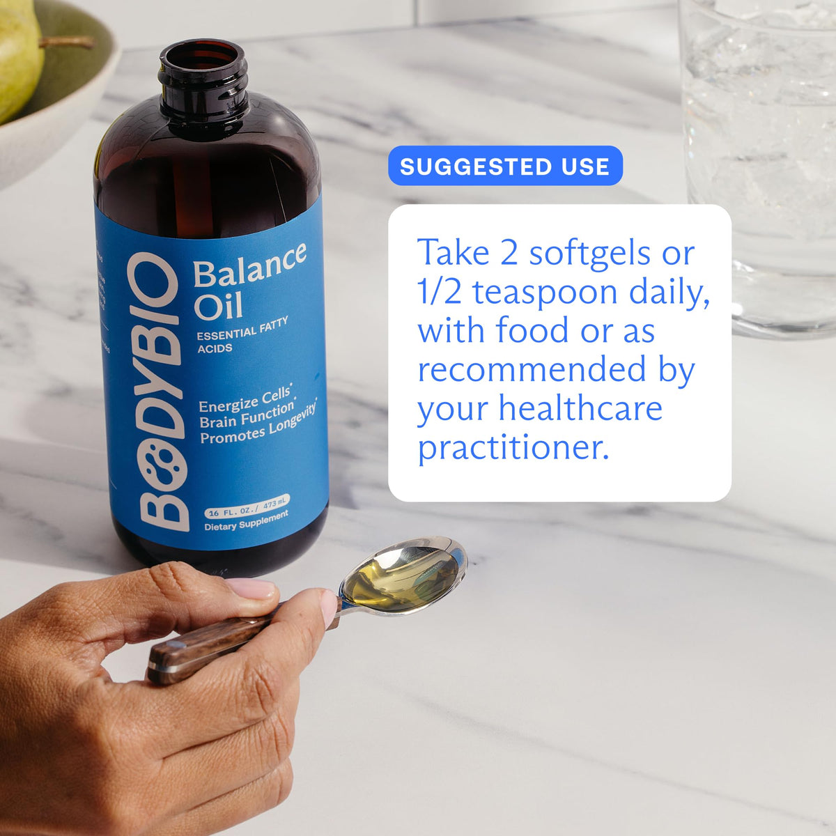 BodyBio Balance Oil sur une table avec des ingrédients frais