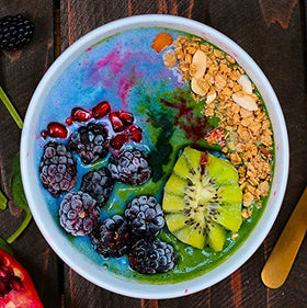 Bol de smoothie décoré avec spiruline bleue et fruits