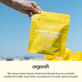 Bonbons Organifi Happy Drops avec fruits frais en arrière-plan