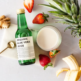 Bouteille de jus d'aloe vera Erbology avec un verre rempli à côté
