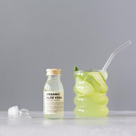 Bouteille de jus d'aloe vera Erbology sur un fond naturel