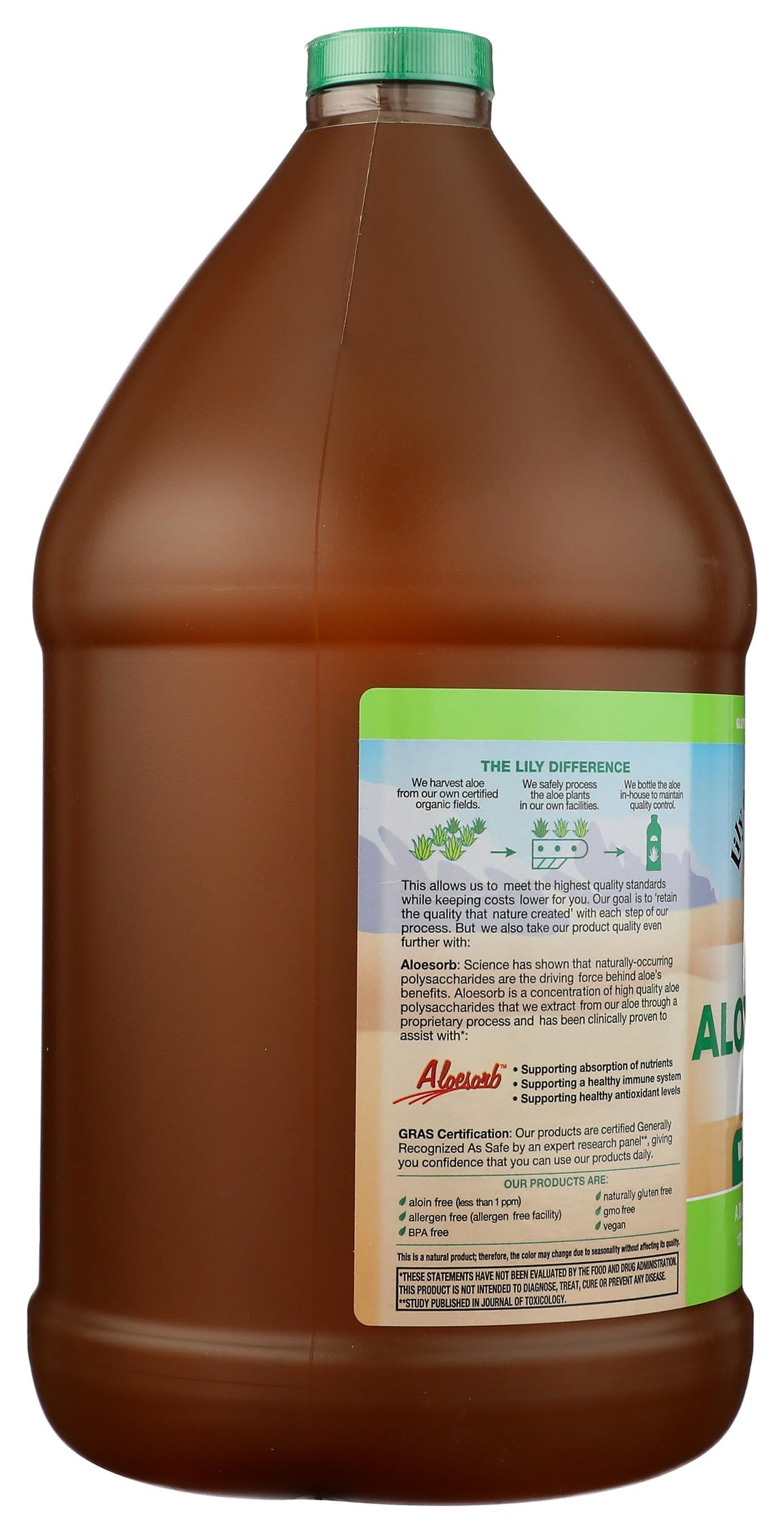 Bouteille de jus d'Aloe Vera Lily Of The Desert sur une table avec des fruits