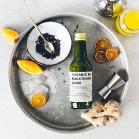 Bouteille de jus de baies de sorbier Erbology sur une table en bois