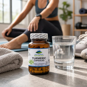 Bouteille et capsules de curcuma sur fond blanc