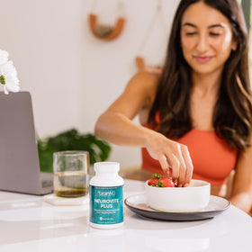 BrainMD NeuroVite Plus 120 capsules à côté d'un verre d'eau