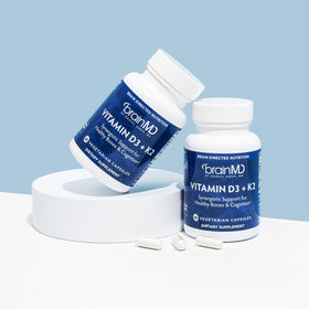 BrainMD Vitamine D3 + K2 capsules et verre d'eau