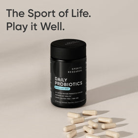Capsules de Probiotiques Quotidiens Sports Research à côté d'un verre d'eau