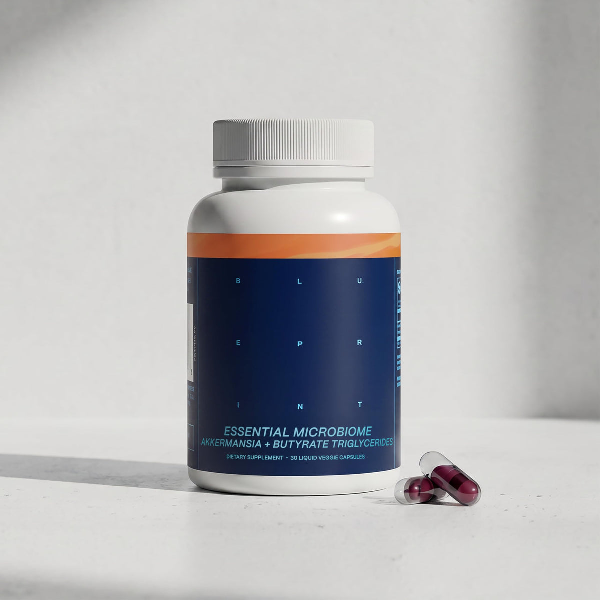 Capsules microbiome essentielles Blueprint Bryan Johnson avec une main tenant la bouteille