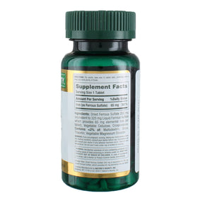Comprimés Nature's Bounty Fer 65 mg près d'un verre d'eau