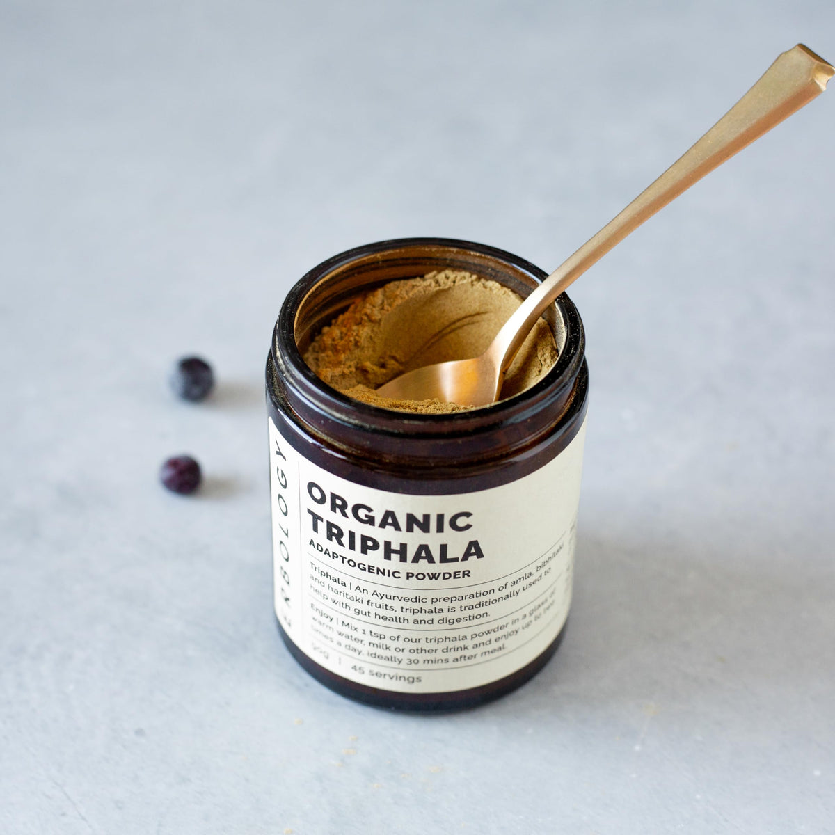 Erbology Poudre de Triphala Bio 90 g avec cuillère en bois sur fond en bois