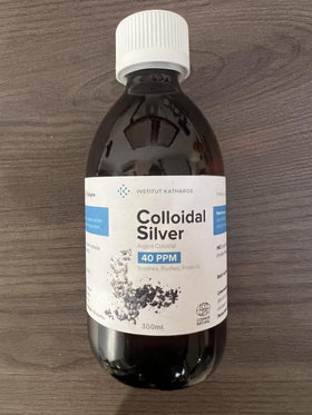 Flacon d'argent colloïdal d'Institut Katharos avec un verre d'eau
