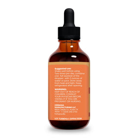 Flacon d'extrait liquide de curcuma HERBANA avec des herbes à côté