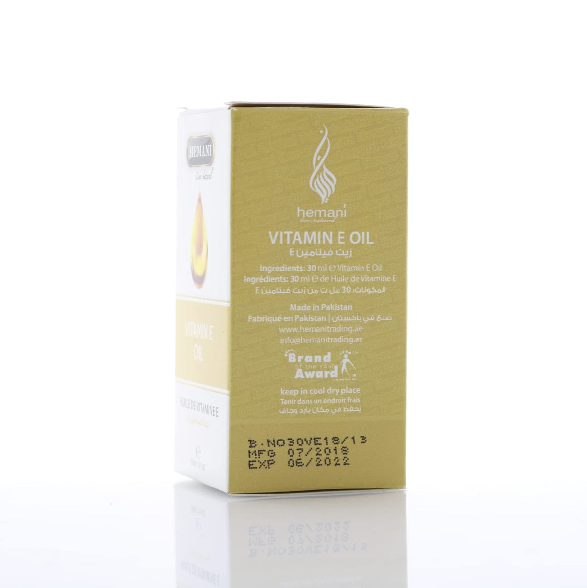 Flacon d'huile de vitamine E Hemani avec goutte sur une table en bois