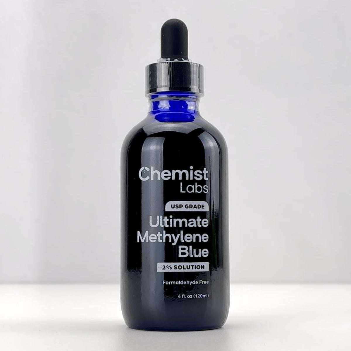 Flacon de méthylène bleu avec dosage à côté d'un verre