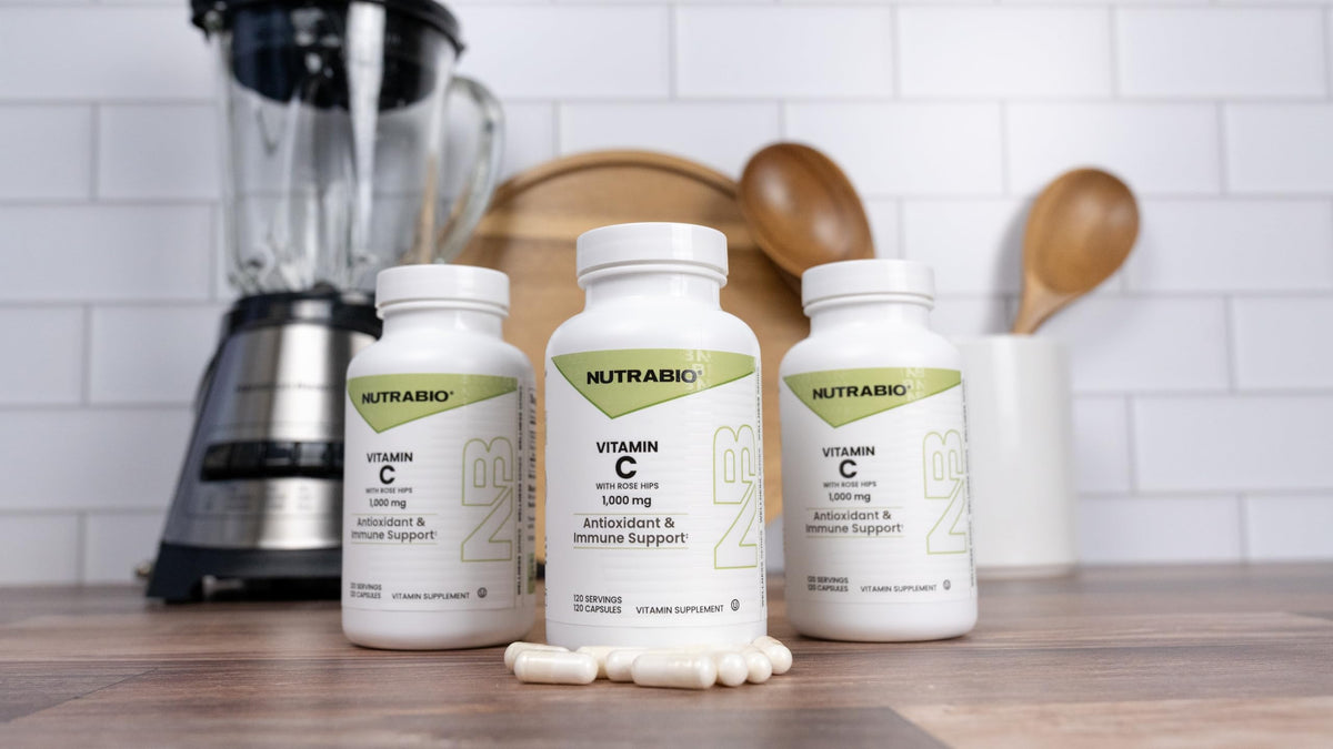 Flacon de Vitamine C NutraBio avec églantier sur un fond naturel