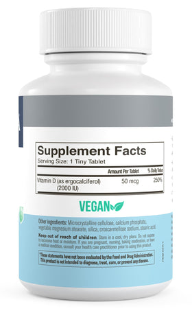 FREEDA Vitamine D2 2000 UI Vegan comprimés à côté d'une assiette de fruits