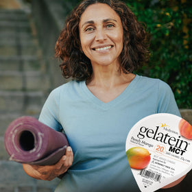Gelatein MCT Pêche Mangue sur une table avec accessoires de fitness