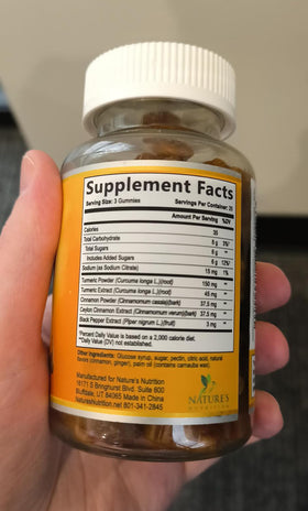 Gélifiés au curcuma Nature's Nutrition sur une table en bois