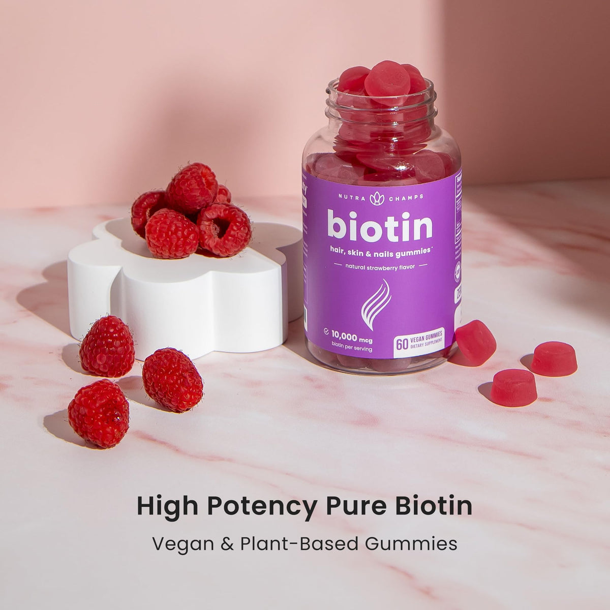 Gélifiés biotine NutraChamps sur une table, avec des ingrédients naturels