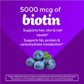 Gummies biotine Vitafusion sur une table en bois