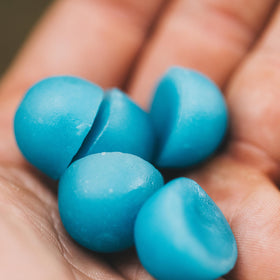 Gummies de créatine MTN OPS dans une main avec un fond naturel