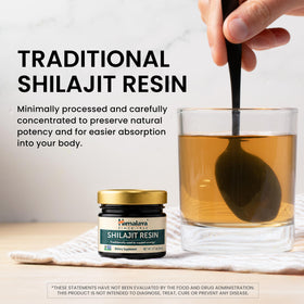 Himalaya Shilajit Résine à côté d'une tasse d'eau chaude