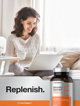 Horbäach Vitamine E 400 IU capsules à côté d'un verre d'eau