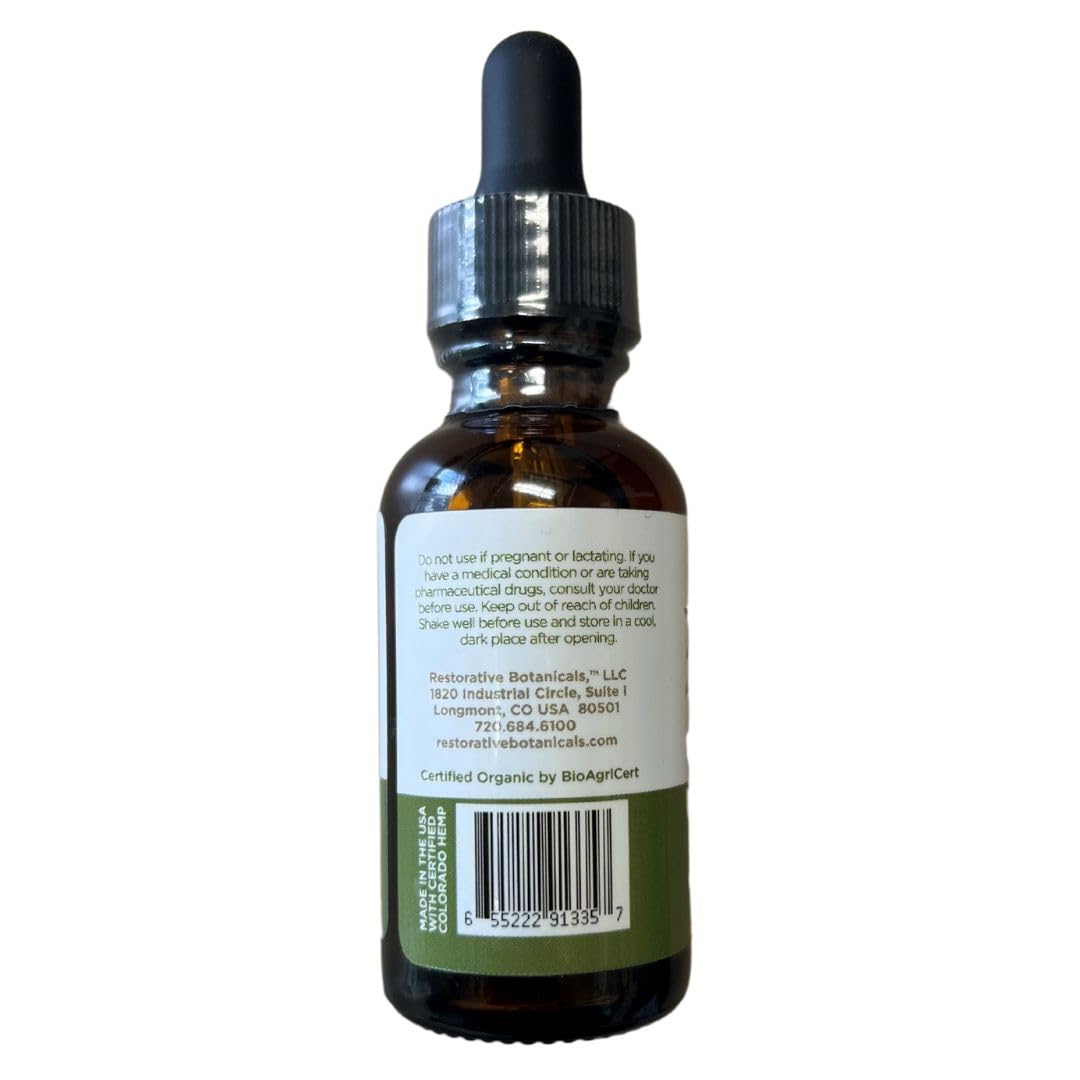 Huile de chanvre bio Restorative Botanicals à côté d'orange mandarine