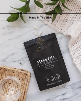 LongLiv Sleep Trio capsules with a glass of water