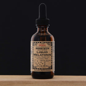 Mélatonine liquide Svasthya sur une table en bois