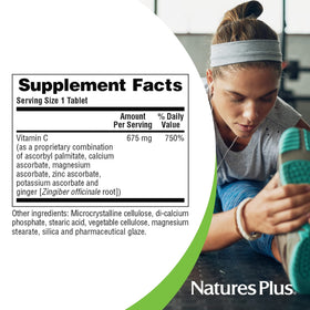 NaturesPlus Esterified Vitamin C 675 mg comprimés à côté d'un verre d'eau
