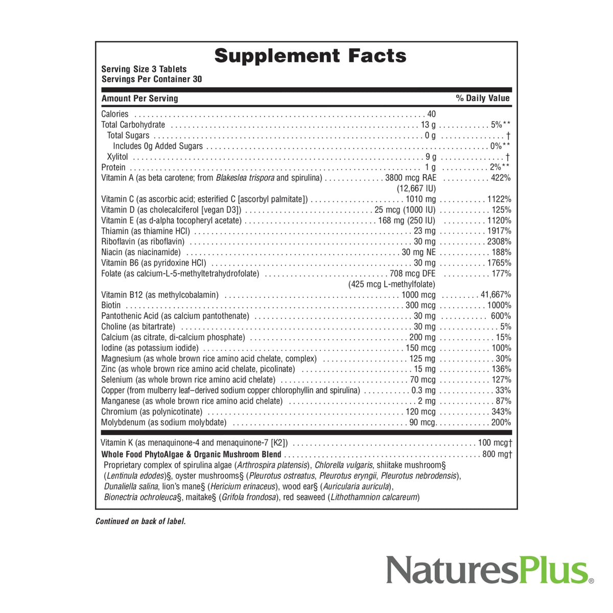 NaturesPlus Source of Life GOLD comprimés à côté d'un verre d'eau
