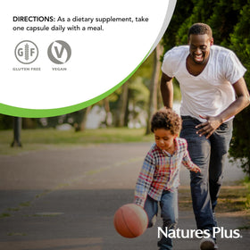 NaturesPlus Ultra One Daily capsules à côté d'un verre d'eau