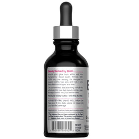 NeoCell Biotin Liquide 10 000 mcg versé dans un verre avec des baies