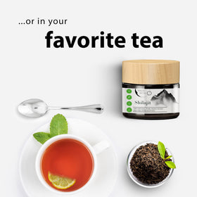 Pot de résine de shilajit avec cuillère en métal sur fond blanc