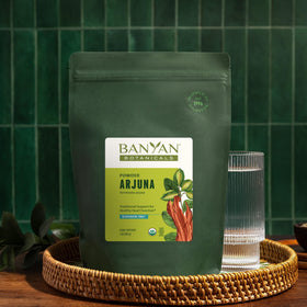Poudre d'écorce d'Arjuna dans un bol avec des herbes