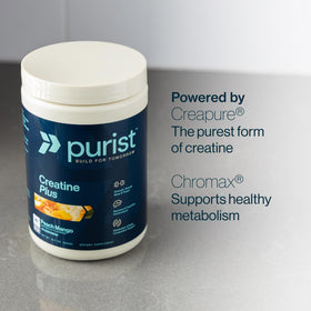 Poudre de créatine Creapure PURIST 349g sur une table avec un verre d'eau