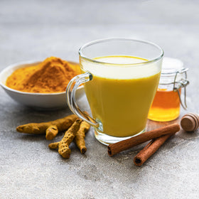 Poudre de curcuma ajoutée à un plat de curry