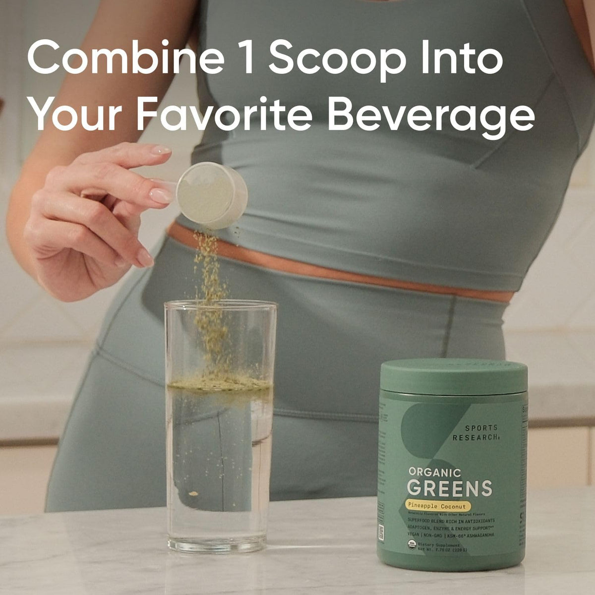 Poudre de super-aliments bio Sports Research 220g à côté d'un verre d'eau