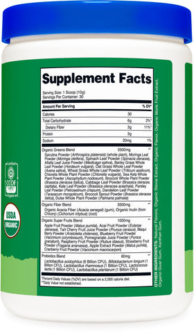 Poudre de super greens bio Nutricost sur une table avec des accessoires de fitness