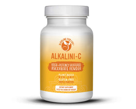 Poudre de vitamine C Alkaline for Life sur une table avec des fruits