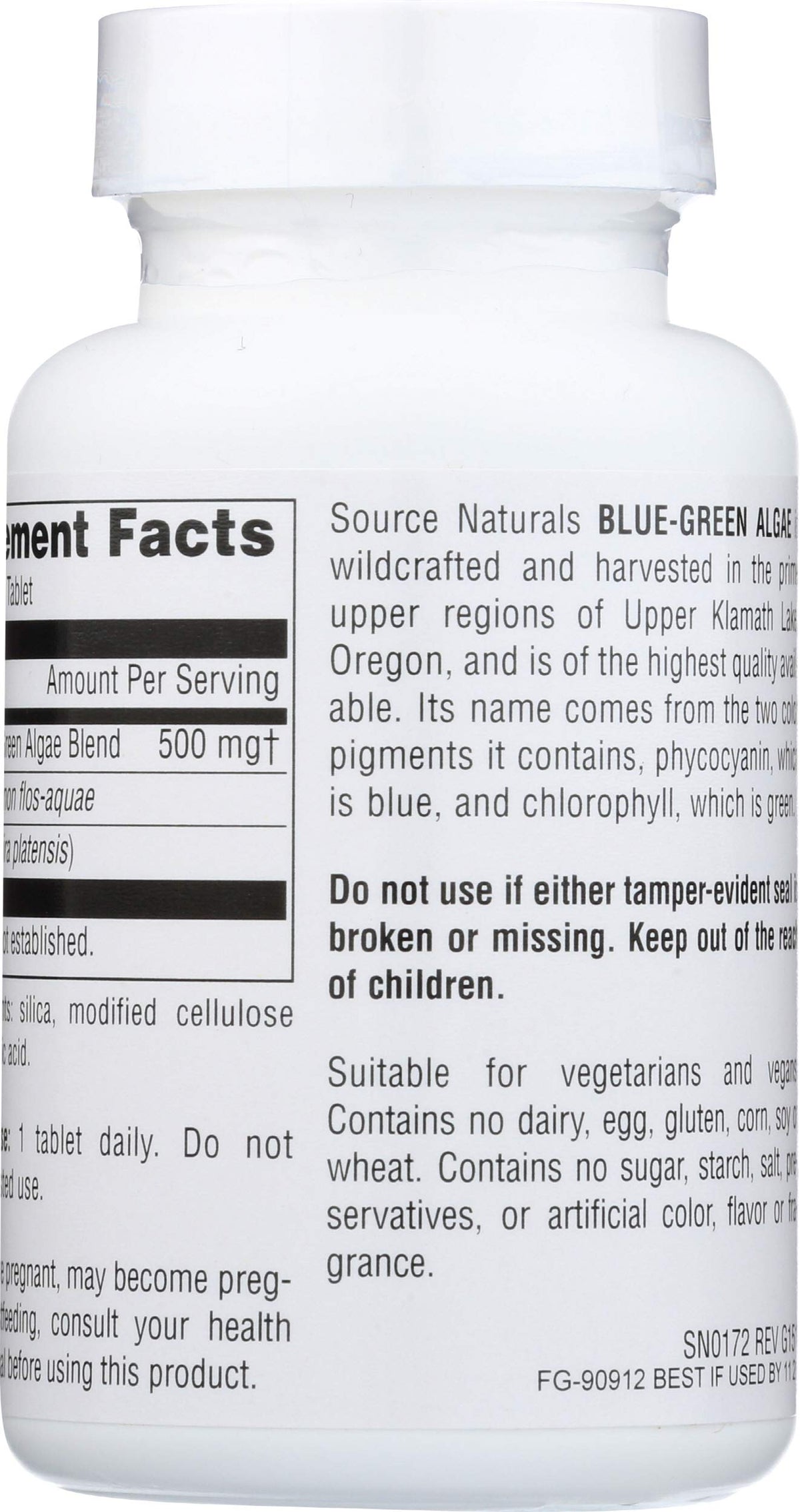 Source Naturals Algue Bleu-Vert comprimés à côté d'un verre d'eau