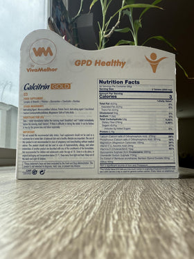 Soy Sano Calcitrin Gold sur une table avec des plantes