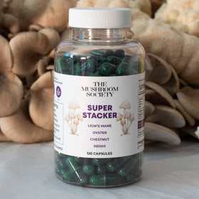 The Mushroom Society Super Stacker 4-en-1 capsules with a measuring spoon