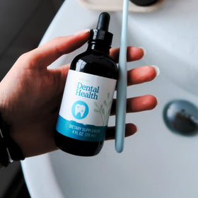 Tincture de santé dentaire SPRIGS à côté d'un verre d'eau