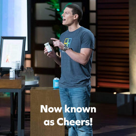 Un verre d'eau à côté de Cheers Restore sur une table