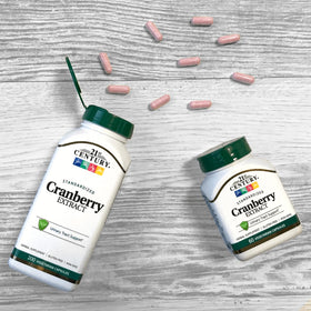 Une main tenant les capsules de canneberge 21st Century dans un cadre naturel