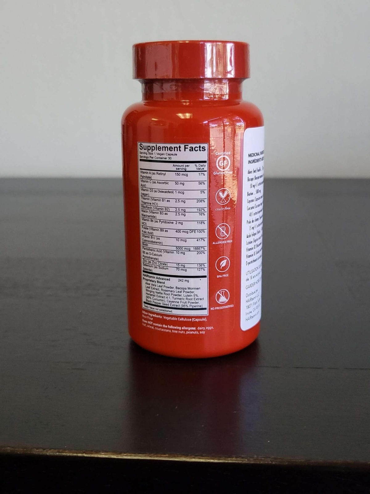 Vue du flacon HAIRtamin avec capsules en arrière-plan